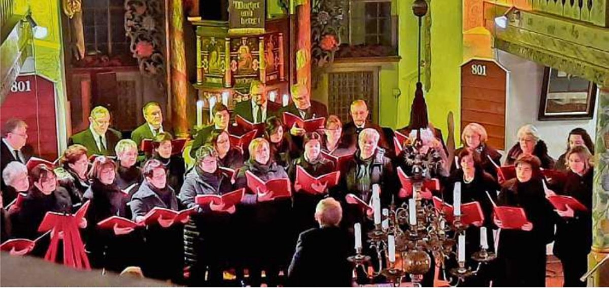 Das Bild zeigt den Altarbereich der Ebersdorfer Kirche mit vielen Sängerinnen und Sängern anlässlich des Adventskonzertes.
