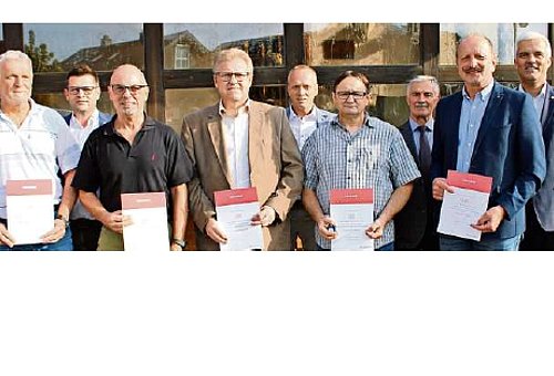 Eine Gruppe Männer. Sie halten jeweils eine Urkunde in der Hand. Am rechten Bildrand steht der Bürgermeister der Stadt Ludwigsstadt. 