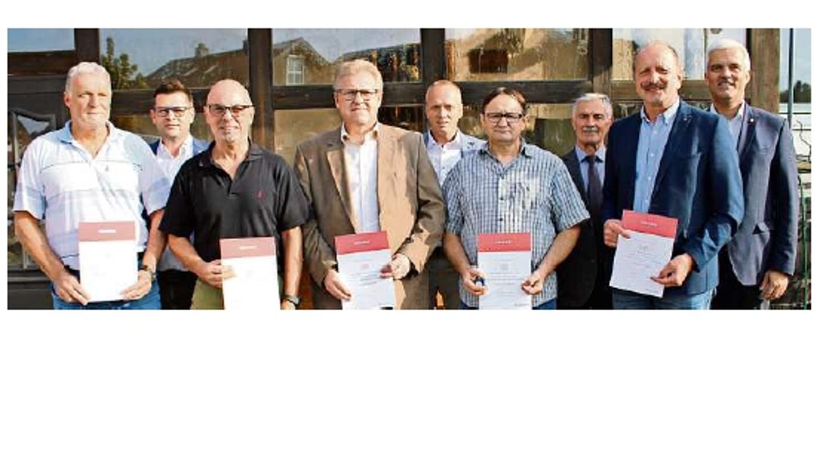 Eine Gruppe Männer. Sie halten jeweils eine Urkunde in der Hand. Am rechten Bildrand steht der Bürgermeister der Stadt Ludwigsstadt. 