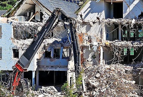 Das Foto zeigt einen Abrissbagger, der bereits Teile des Sparkassengebäudes eingerissen hat. 