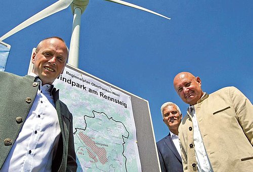 Das Bild zeigt die drei Bürgermeister der Rennsteigregion mit Windrad im Hintergrund.