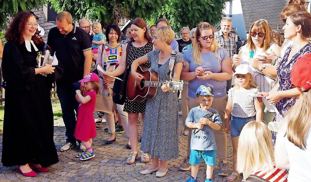 Das Foto zeigt eine Gruppe von Menschen verschiedener Alter. Darunter die Pfarrerin Frau Pöhlmann in ihrem Talar.