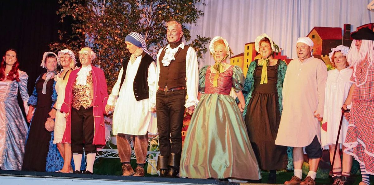 Das Foto zeigt die Schauspieler gemeinsam auf der Bühne beim Verbeugen. 