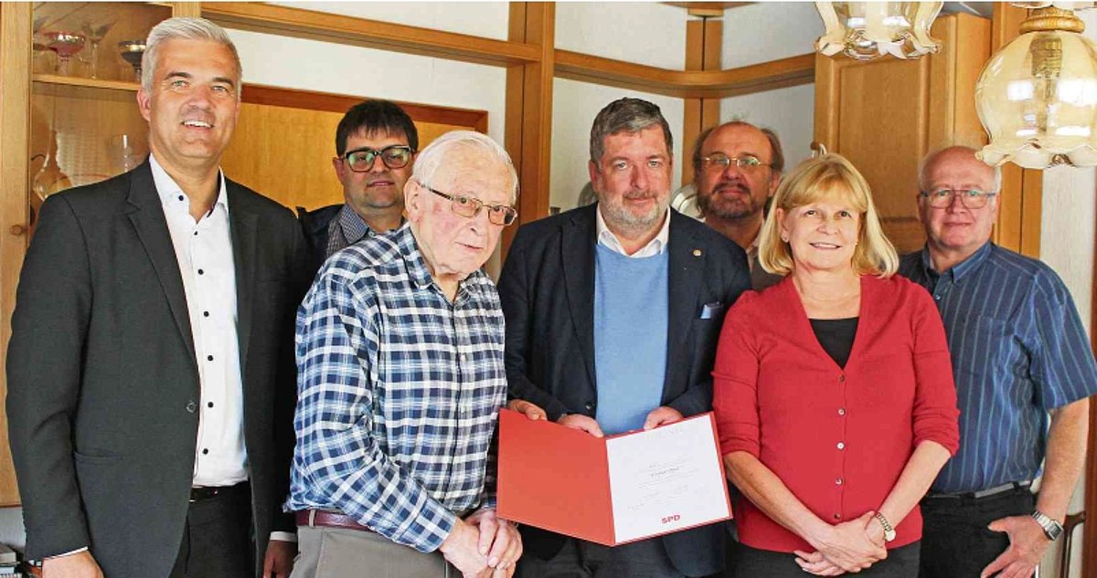 Das Foto zeigt eine Gruppe von Menschen, in deren Mitte der Jubilar steht. Sie alle schauen in die Kamera.