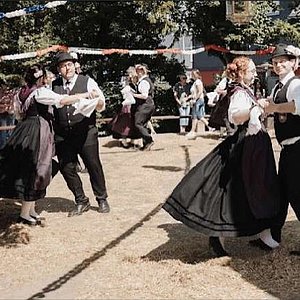 Drei Tanzpaare in historischer Tracht tanzen im Kreis auf dem Anger in Ebersdorf