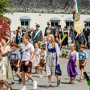Im Festumzug läuft auch die Schützenjugend mit. Das sind Jungen und Mädchen in Trachten. Sie haben auch den Holzadler dabei, der traditionell zum Vogelschießen gehört.