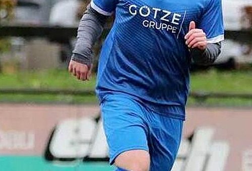 Zu sehen ist ein junger Fußballer des TSV Ludwigsstadt mit blauem Trikot in Aktion auf schlechtem Geläuf.