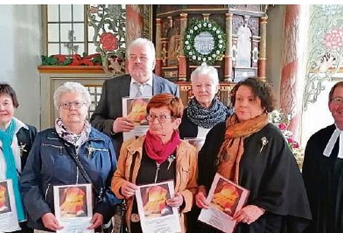 Fünf Frauen und ein Mann stehen mit dem Pfarrer in der Kirche. 