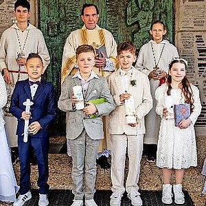 Die Kinder stehen in einer Gruppe mit Ihren Kommunionskerzen