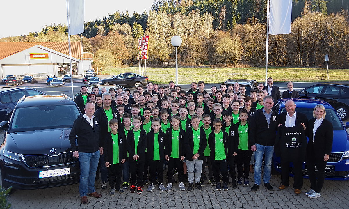 Kindersportgruppe mit Trainern in neuen Jacken