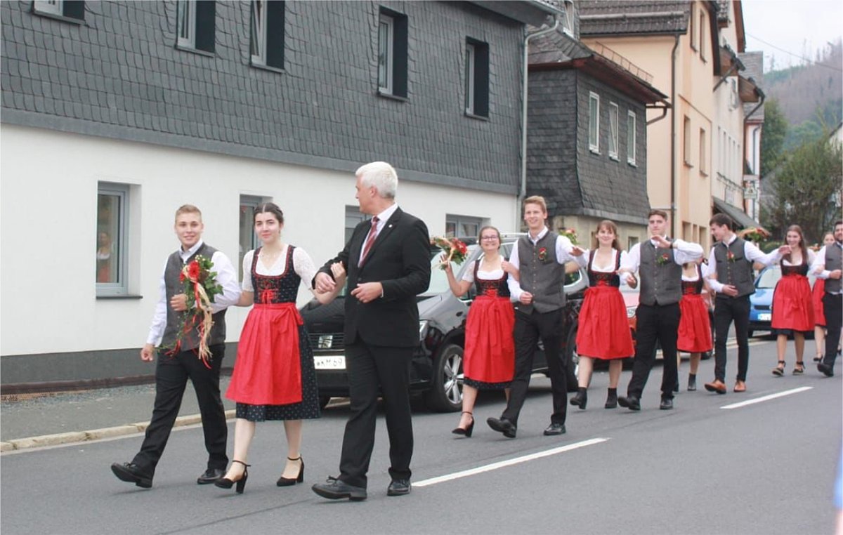 Das Bild zeigt die Kirchweihpaare in ihren Trachten. Sie laufen paarweise im Festzug. Mit dem ersten Paar läuft der Bürgermeister Timo Ehrhardt.