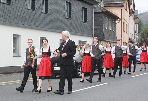 Das Bild zeigt die Kirchweihpaare in ihren Trachten. Sie laufen paarweise im Festzug. Mit dem ersten Paar läuft der Bürgermeister Timo Ehrhardt. 