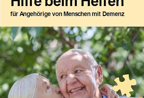 Ein Flyer. Darauf ein Bild von einer älteren Frau mit grauen Haaren und einem älteren Mann mit wenig Haaren. Sie küsst ihn auf die Wange. Er lächelt.