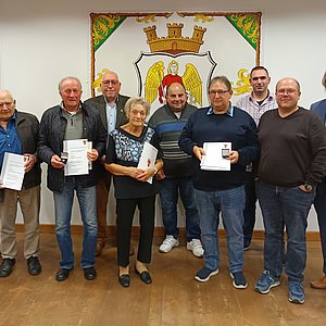 Zu sehen sind die Geehrten, drei Männer und eine Frau mit Urkunde und silberner Ehrennadel sowie Bürgermeister und Stadtratskollegen und der weitere Stellvertreter des Landrats.