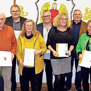 Eine Grupppe von Männern und Frauen stehen zusammen und schauen in die Kamera. Sie halten ihre Urkunden in den Händen. Mit dabei der Landrat und der Bürgermeister.
