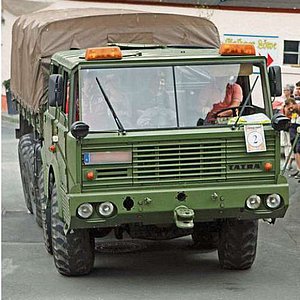 Das Bild zeigt einen grünen alten Unimog mit Planenaufbau.