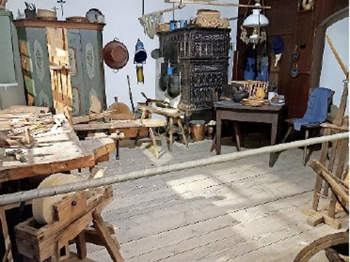 Das Foto zeigt die Tafelmacherstube im Museum mit alten Möbeln und Arbeitsgeräten für die Herstellung von Schiefertafeln.