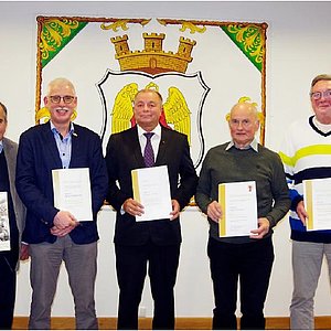 Das Foto zeigt eine Gruppe von Männern. Die Geehrten halten eine Urkunde in den Händen. Mit dabei auch der Landrat und der Bürgermeister. Sie alle schauen in die Kamera.