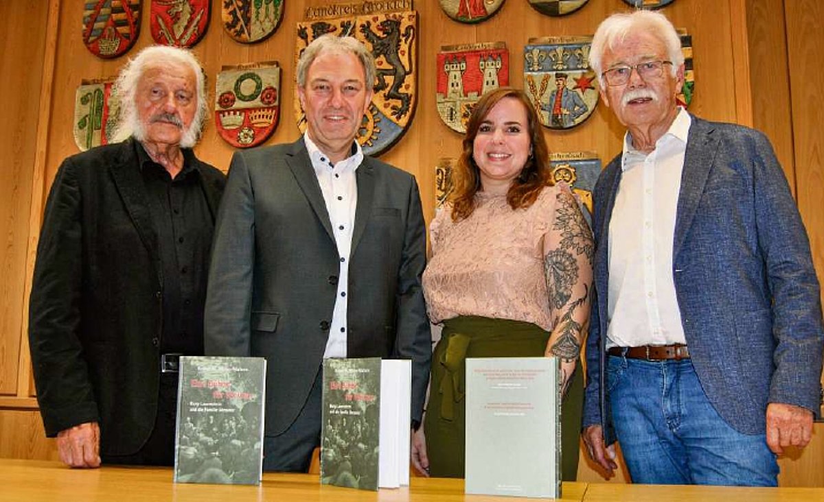 Drei Männer darunter der Landrat Klaus Löffler und die Kulturreferentin stehen hinter einem Tisch und schauen in die Kamera. Vor ihnen auf dem Tisch stehen drei Exemplare des neuen Buches. 