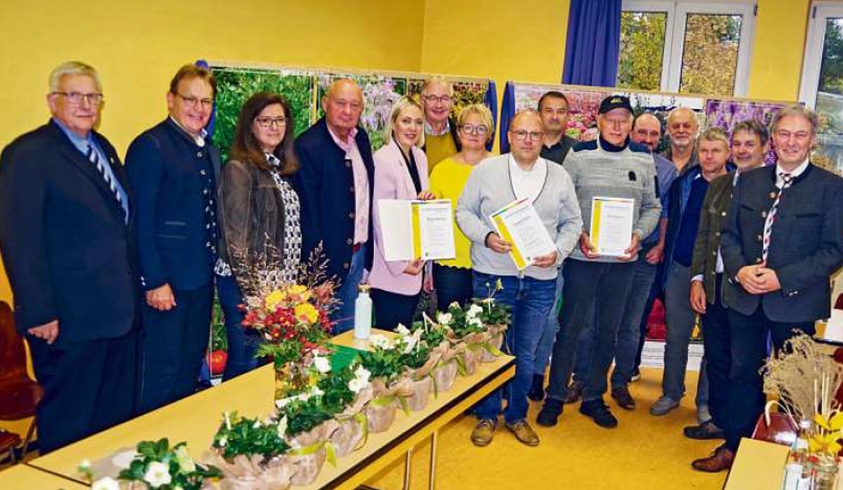 Das Foto zeigt eine große Gruppe an Menschen. Einige halten Urkunden in der Hand. Alle schauen in die Kamera.