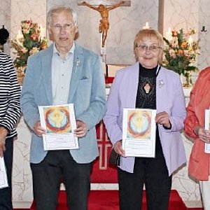 Vor einem Kirchenaltar stehen sechs alte Menschen. Darunter zwei Männer, einer davon in schwarzer Pfarrerrobe.
