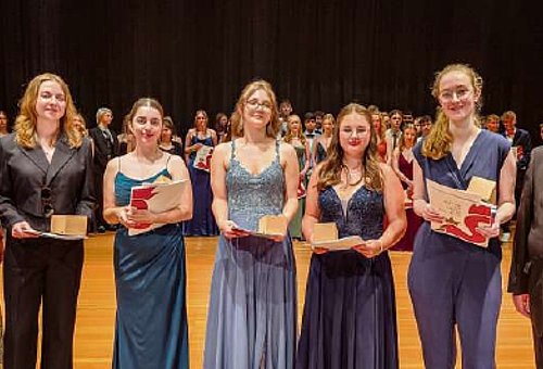 5 junge Frauen, die Schülerinnen mit einem "Echten" Einserabitur stehen in einer Reihe. Umrahmt werden sie auf der einen Seite von ihrer Schulleiterin und auf der anderen Seite vom stellvertretenden Landrat Bernd Steger. 