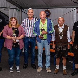 Fünf Sieger stehen mit dem Sportwart der Schützen in einer Gruppe. Die fünf Sieger - ein Frau und vier Männer - halten stolz ihre Pokale. Sie schauen alle in die Kamera.
