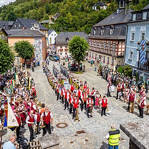 Zu sehen ist der historische Marktplatz Ludwigsstadt. Hier findet beim Festumzug die Fahnenabholung statt. Der gesamte farbenprächtige Festumzug hat sich hier versammelt.