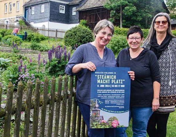 Drei Frauen stehen vor dem Garten in Steinbach an der Haide und halten ein Plakat in die Kamera.