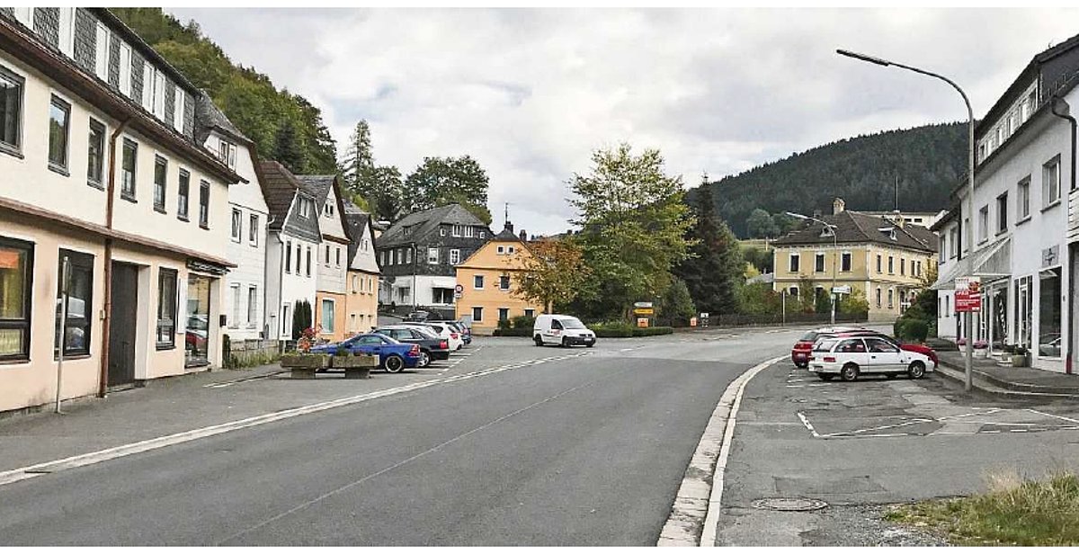 Blick auf eine Straße mit Wohn- und Geschäftshäusern.