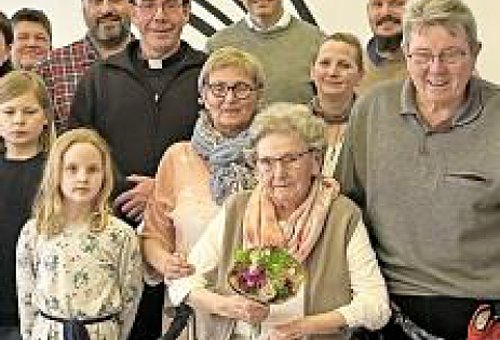 Eine Gruppe von Menschen, die Familie der Jubilarin. Sie ist in der Mitte im Vordergrund zu sehen.