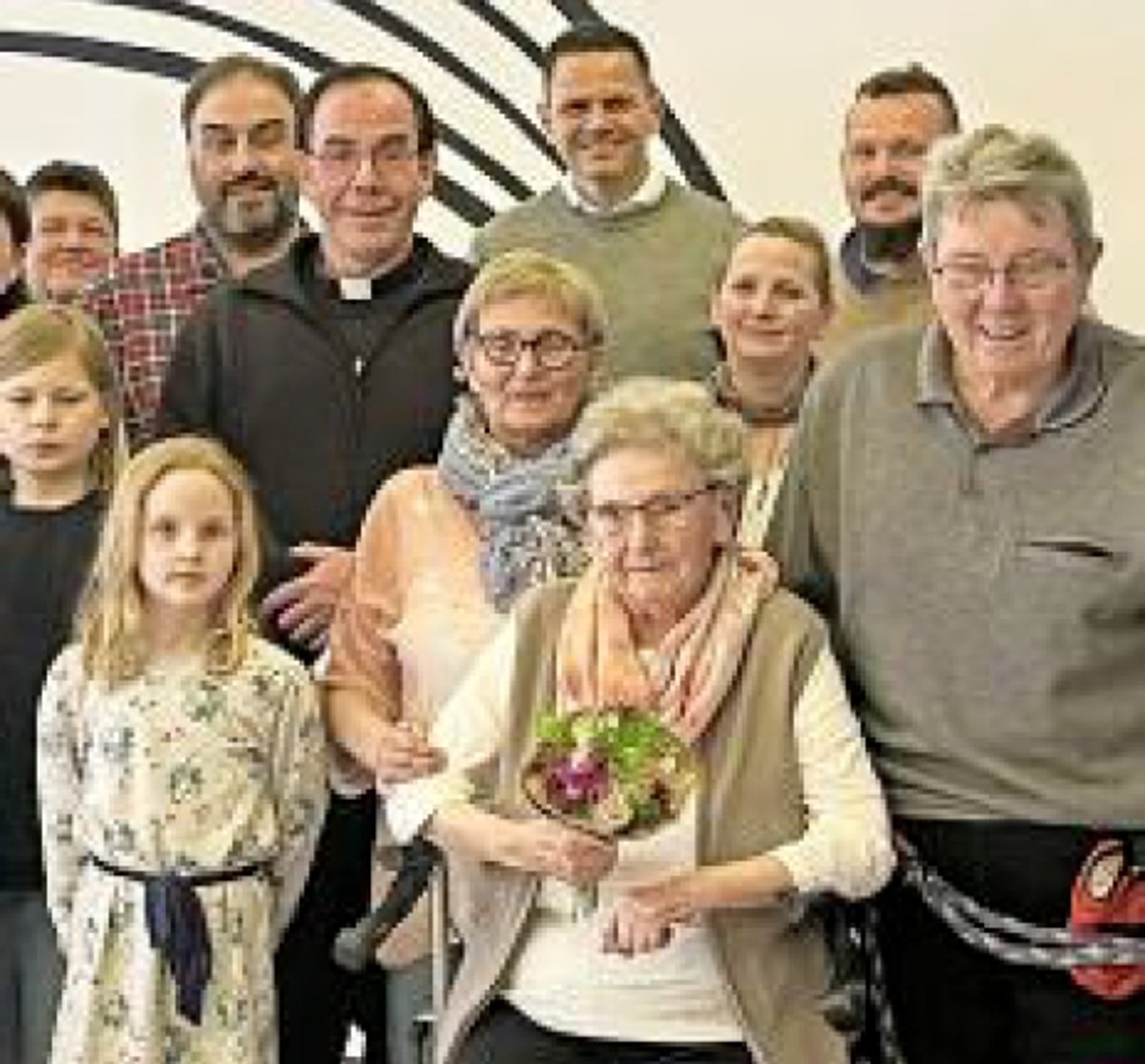 Eine Gruppe von Menschen, die Familie der Jubilarin. Sie ist in der Mitte im Vordergrund zu sehen.
