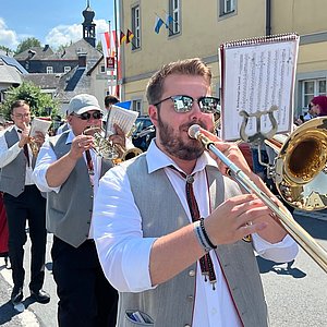 Musiker mit Instrumenten und Uniform während sie im Umzug spielen und marschieren.