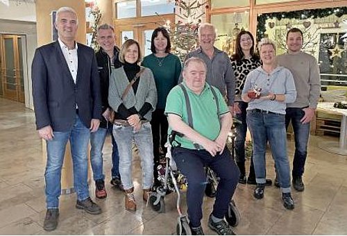 Links ist Bürgermeister Timo Ehrhardt mit einer Gruppe von Frauen und Männern bei der Spendenübergabe zu sehen.