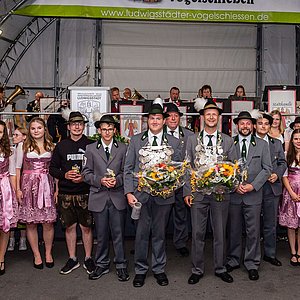 Im Halbkreis stehen außen die Schützenliesel und dazwischen der neue Schützenkönig und seine Ritter.