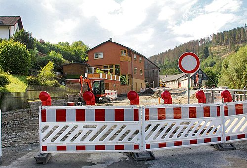Das Bild zeigt ein Sperrschild und viele Absperrbaken auf der B 85 Ortsdurchfahrt Ludwigsstadt in Höhe der ehemaligen Autowerkstatt Lorenz.