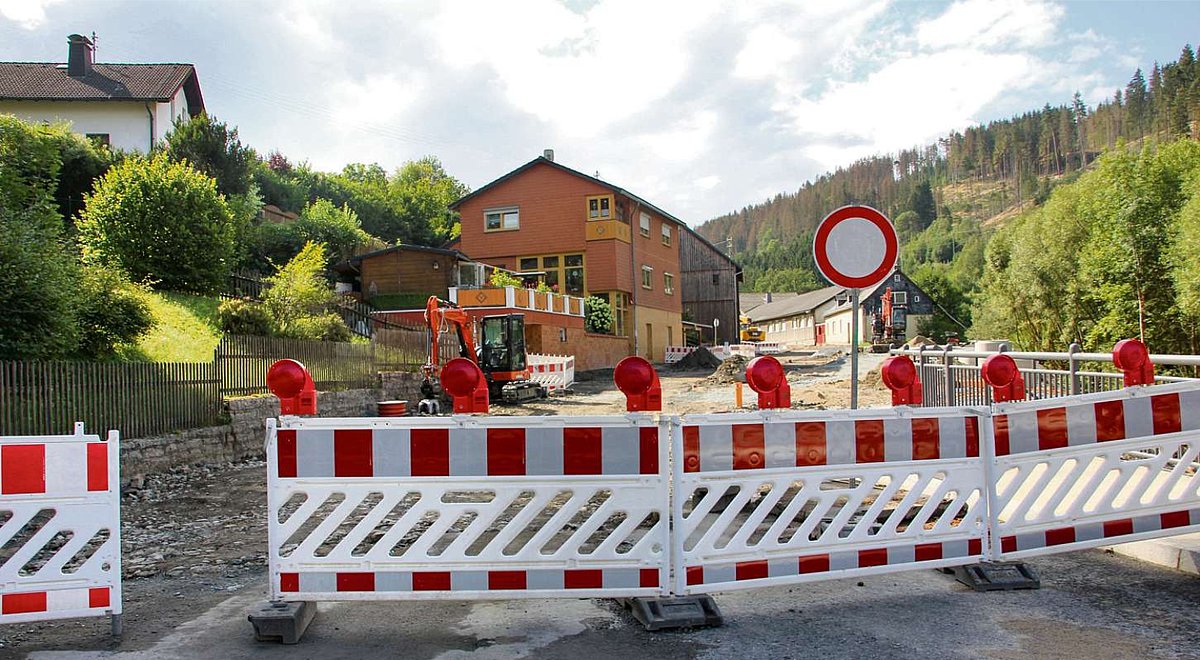 Das Bild zeigt ein Sperrschild und viele Absperrbaken auf der B 85 Ortsdurchfahrt Ludwigsstadt in Höhe der ehemaligen Autowerkstatt Lorenz.