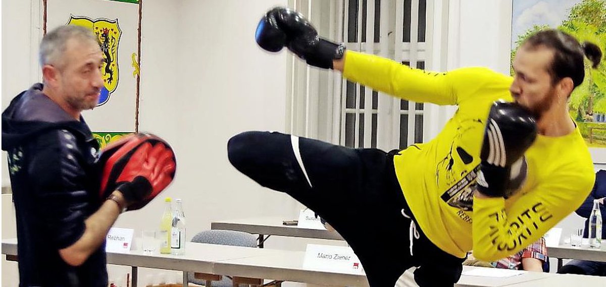 Auf dem Bild sind zwei Männer zu sehen, die ihren Kampfsport demonstrieren.