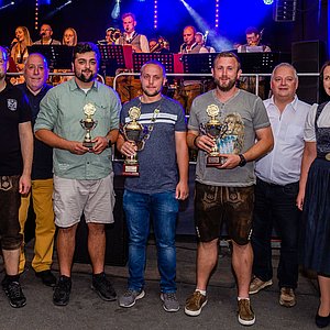 Das Foto zeigt eine Gruppe von Menschen; eine Frau im Dirndl und sechs Männer. In der Mitte steht der diesjährige Jedermannkönig mit seiner Kette und seinem Pokal. Alle schauen zum Fotografen.