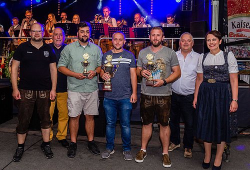Das Foto zeigt eine Gruppe von Menschen; eine Frau im Dirndl und sechs Männer. In der Mitte steht der diesjährige Jedermannkönig mit seiner Kette und seinem Pokal. Alle schauen zum Fotografen.