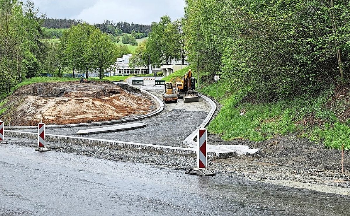 Straße mit Warnbarken und fehlender Asphaltschicht.