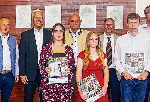 Das Foto zeigt die drei jungen Absolventen mit Schulleiter, Klassenleiter und den Bürgermeistern von Steinbach am Wald, Ludwigsstadt und Tettau. Alle tragen festliche Kleidung und lächeln in die Kamera. 