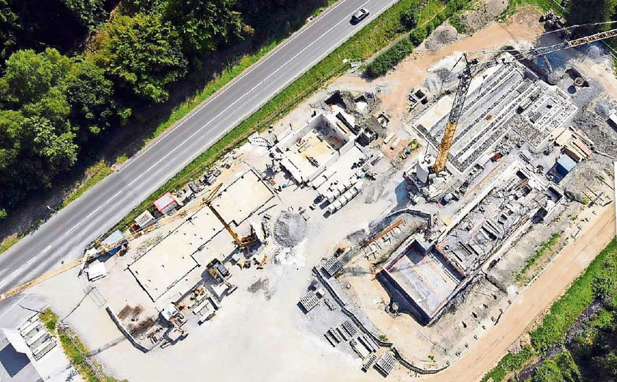 Eine große Baustelle von oben. Man sieht planierte Flächen, Schwimmbecken, Gebäudemauern.
