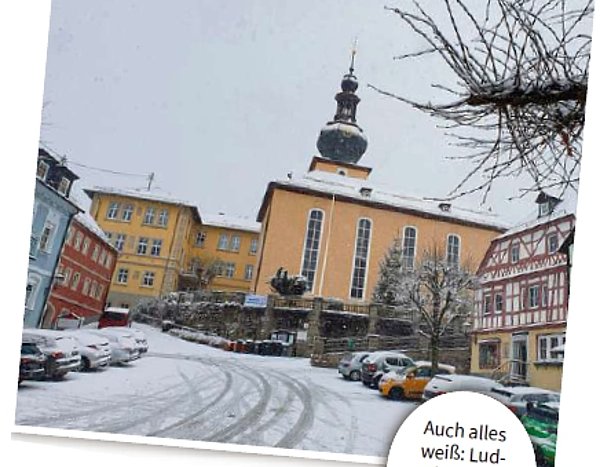 Das Bild zeigt den Marktplatz mit Kirche unter einer dünnen Schneedecke. 