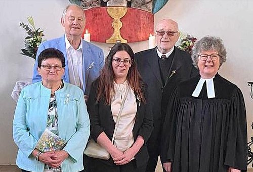 Auf dem Bild sind vor dem Altar der Steinbacher Kirche zwei Frauen und zwei Männer mit Pfarrerin Claudia Grüning-Göll zu sehen.